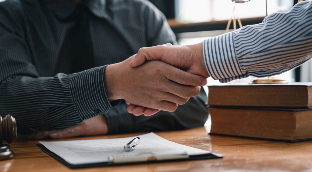 Lawyers shake hands with business people to seal a deal with partner lawyers. or a lawyer discussing